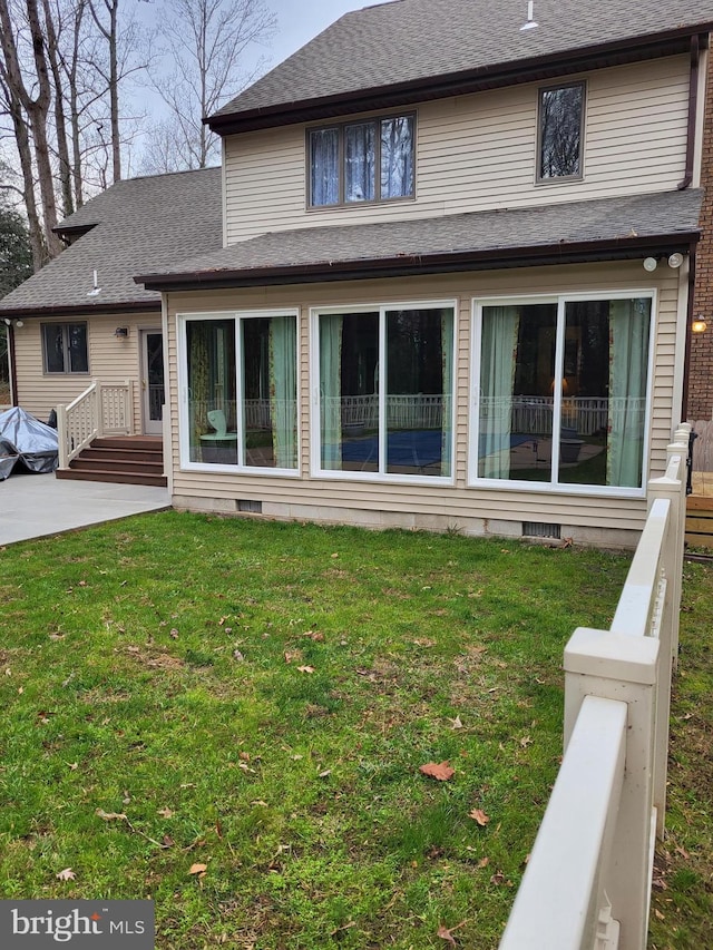 back of property with a yard and a patio area