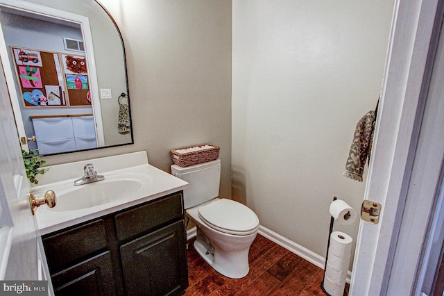 bathroom with hardwood / wood-style flooring, vanity, and toilet