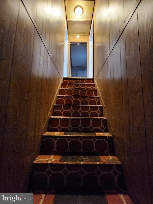 stairway featuring wood walls and a barn door