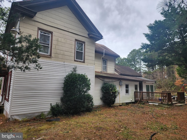 rear view of property with a lawn and a wooden deck