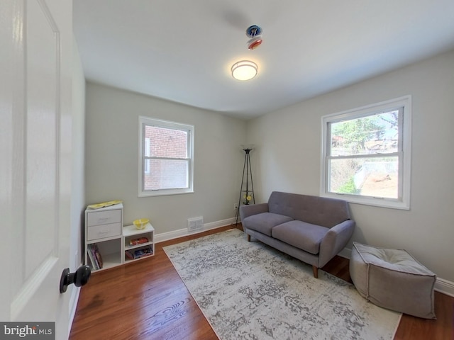 sitting room with visible vents, baseboards, and wood finished floors