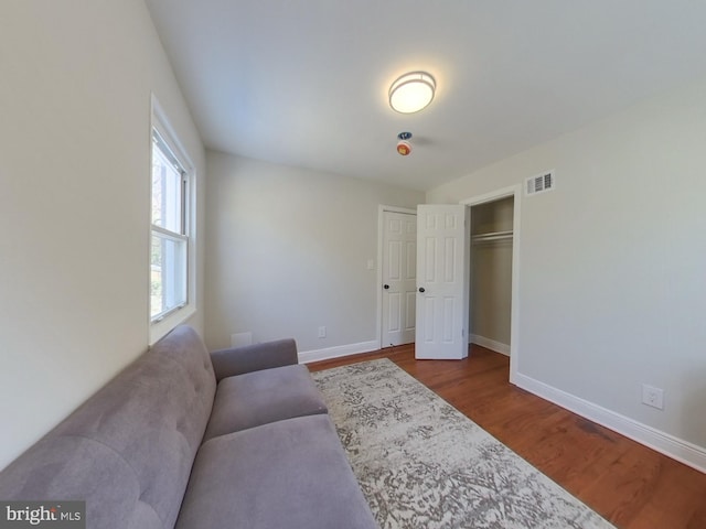 living room with visible vents, baseboards, and wood finished floors