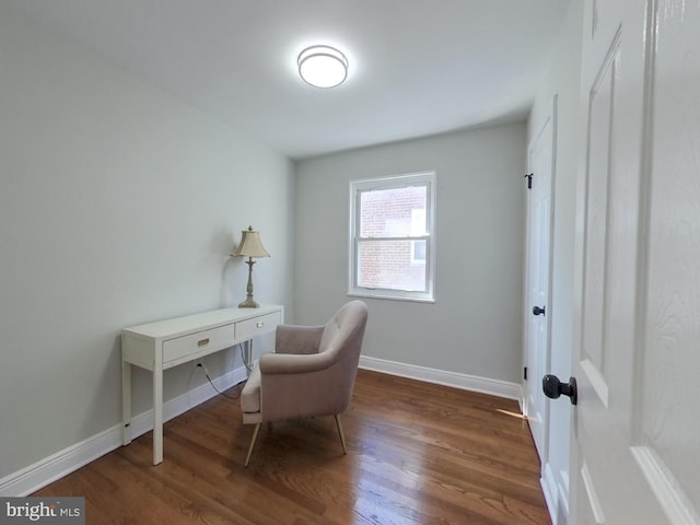 living area featuring baseboards and wood finished floors