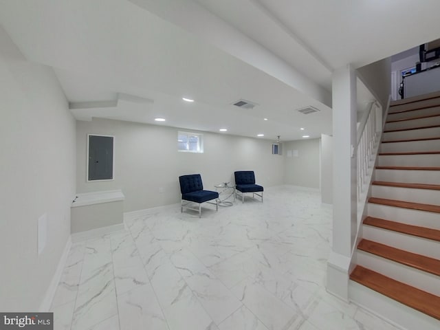 living area featuring electric panel, visible vents, baseboards, and marble finish floor