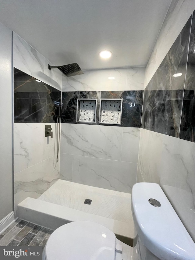 bathroom with toilet and tiled shower