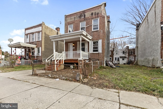 multi unit property with a porch and a front lawn