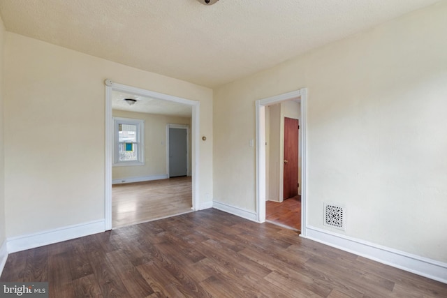 empty room featuring wood-type flooring and a textured ceiling