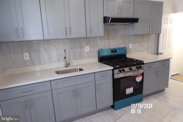 kitchen featuring gray cabinetry, sink, extractor fan, and range with gas cooktop