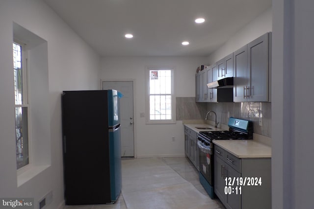 kitchen with black appliances, gray cabinets, sink, and tasteful backsplash