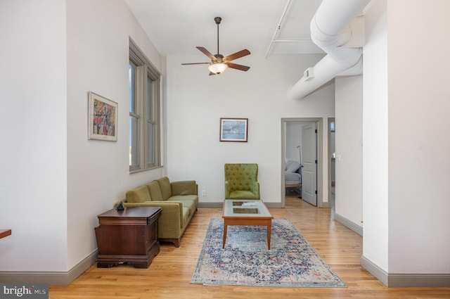 living room with ceiling fan and light wood-type flooring