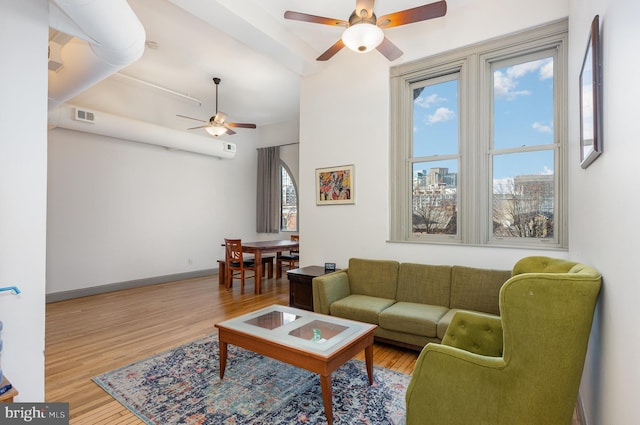 living room featuring wood-type flooring and ceiling fan