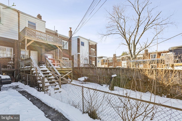 yard layered in snow with a balcony