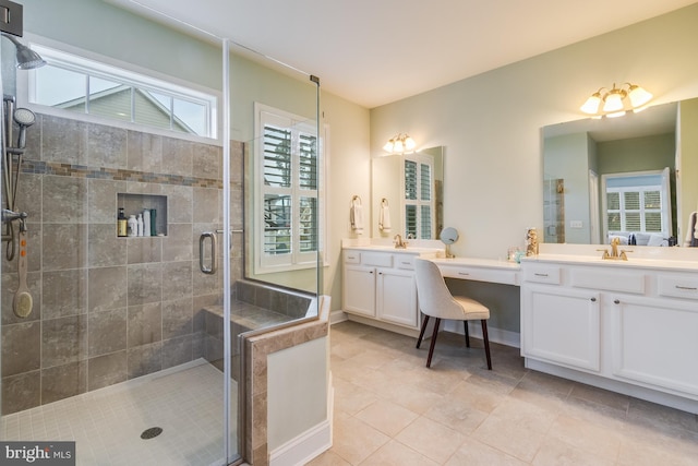 bathroom featuring tile patterned floors, a wealth of natural light, a shower with door, and vanity