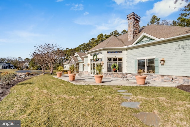 back of house with a lawn and a patio