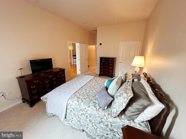 bedroom featuring light carpet and lofted ceiling