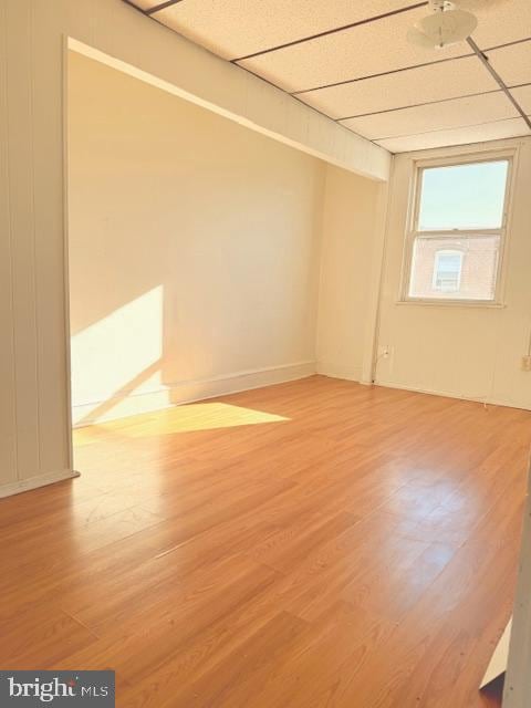 spare room featuring hardwood / wood-style flooring and a drop ceiling