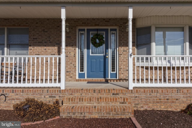 view of exterior entry featuring covered porch