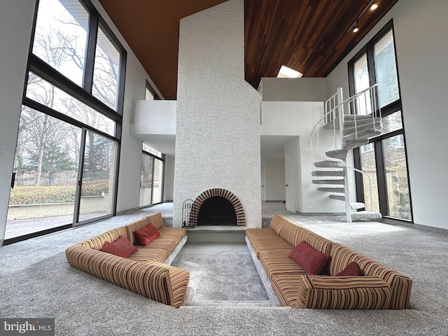 living room featuring carpet flooring, a high ceiling, and a fireplace