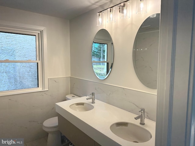 bathroom featuring sink, a healthy amount of sunlight, and toilet