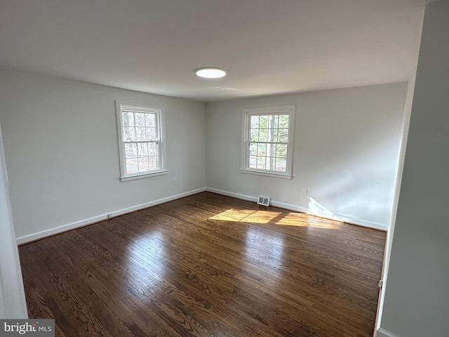 spare room with dark hardwood / wood-style floors