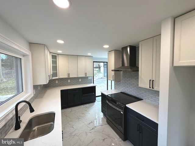 kitchen with decorative backsplash, wall chimney exhaust hood, sink, white cabinetry, and black / electric stove