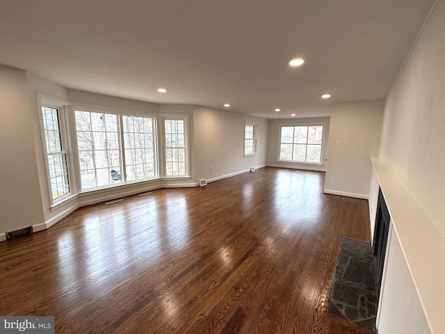 unfurnished living room with a fireplace and dark wood-type flooring