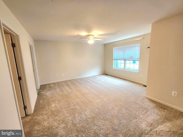 carpeted empty room featuring ceiling fan