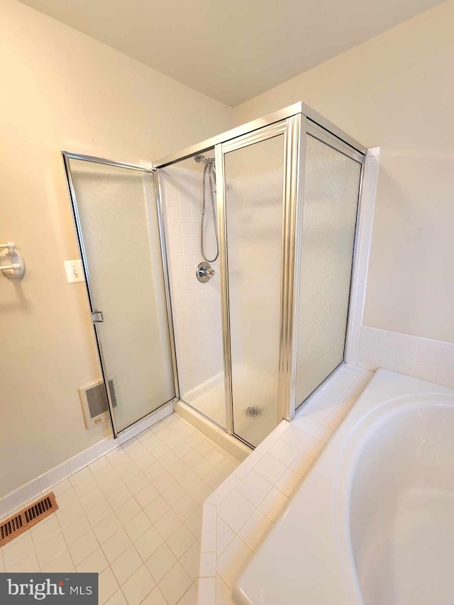 bathroom featuring tile patterned floors and shower with separate bathtub