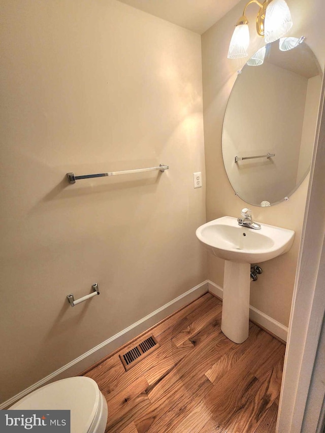 bathroom with wood-type flooring and toilet