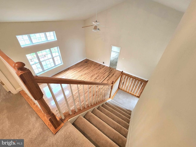 stairs with high vaulted ceiling and ceiling fan