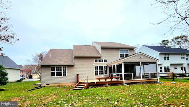 back of property featuring a lawn, a sunroom, and a deck