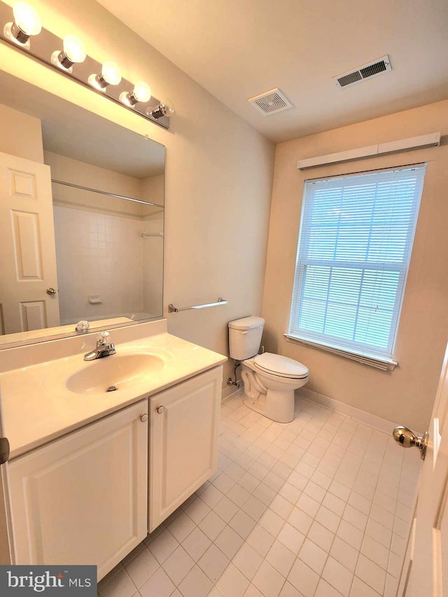 bathroom with tile patterned flooring, vanity, and toilet