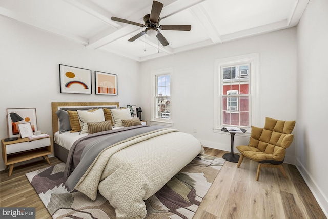 bedroom featuring ceiling fan, hardwood / wood-style floors, beamed ceiling, and coffered ceiling