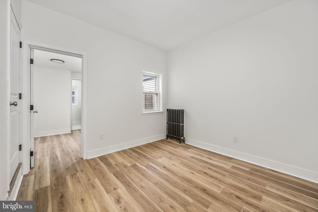 spare room with radiator and light wood-type flooring