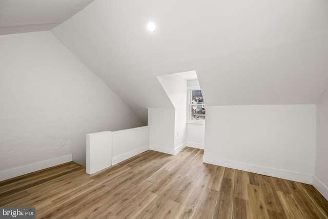 bonus room featuring light hardwood / wood-style floors and vaulted ceiling