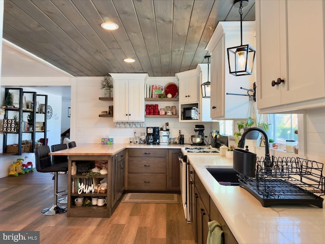 kitchen with stove, hardwood / wood-style flooring, white cabinetry, and wood ceiling