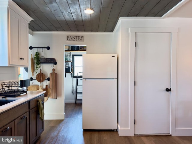 kitchen featuring white cabinets, white refrigerator, wooden ceiling, and dark wood-type flooring