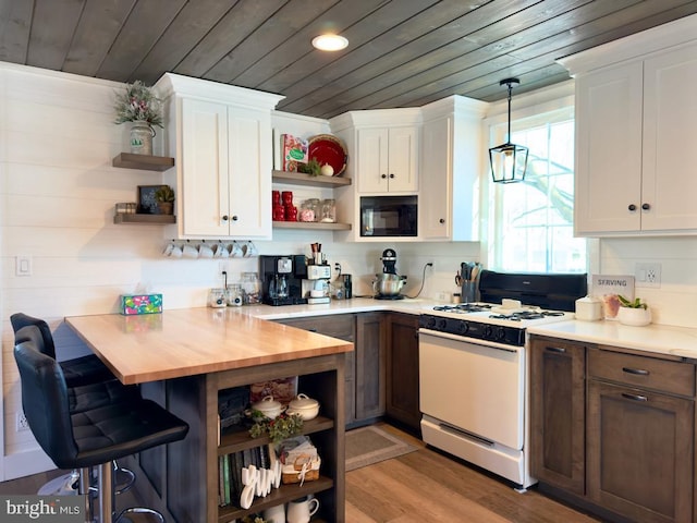 kitchen featuring white cabinets, wooden ceiling, black microwave, and gas range gas stove