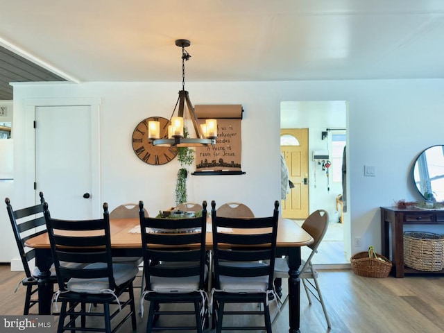 dining room with hardwood / wood-style floors and a notable chandelier