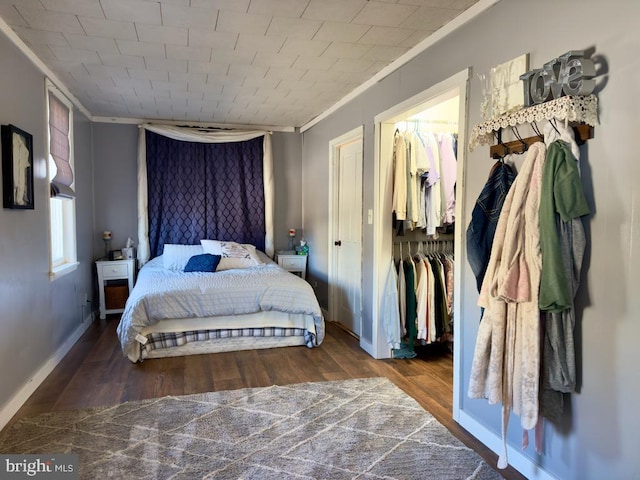 bedroom with a closet, dark hardwood / wood-style floors, and ornamental molding