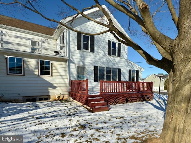 snow covered rear of property with a wooden deck