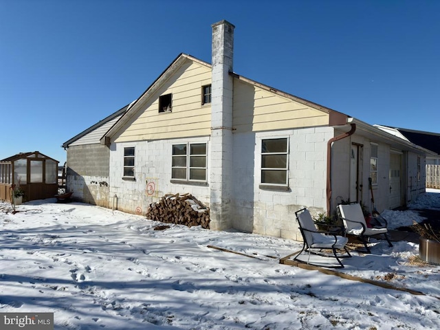 view of snow covered back of property