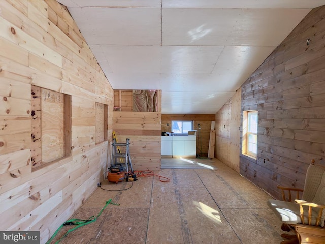 additional living space with wood walls and vaulted ceiling