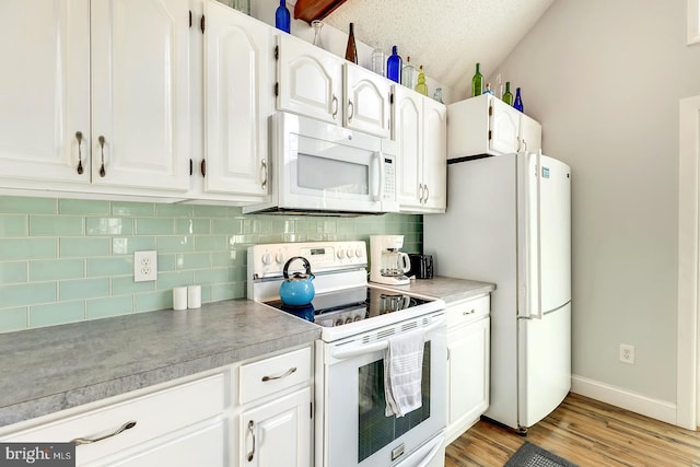 kitchen featuring tasteful backsplash, white appliances, light hardwood / wood-style flooring, white cabinetry, and lofted ceiling