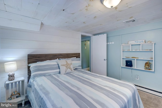 carpeted bedroom with wood ceiling, wooden walls, and a baseboard heating unit