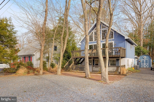 view of front of home with a storage unit, a deck, and central air condition unit