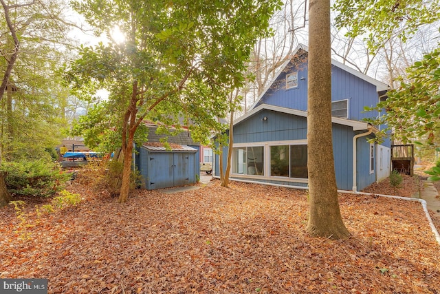 rear view of property featuring a storage unit