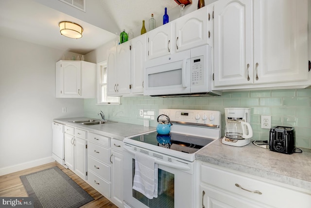 kitchen featuring backsplash, white cabinetry, white appliances, and sink