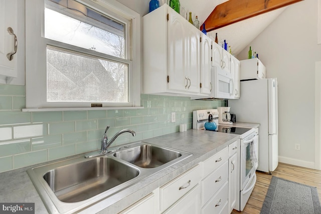 kitchen with white cabinetry, sink, lofted ceiling, white appliances, and decorative backsplash