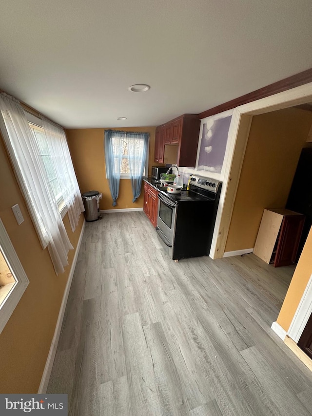 kitchen with appliances with stainless steel finishes and light hardwood / wood-style flooring